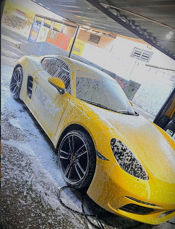 Esportivo amarelo coberto de espuma durante a lavagem na SALUCAR.LAVARAPIDO